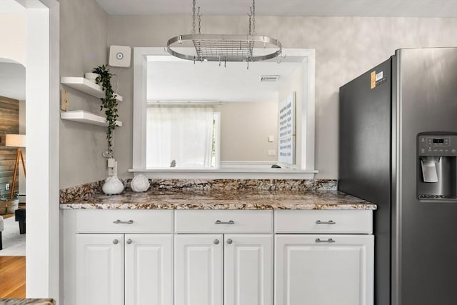 56 Beach St, Woburn, MA 01801 - kitchen with stainless steel refrigerator with ice dispenser, open shelves, white cabinetry, light stone counters, and arched walkways