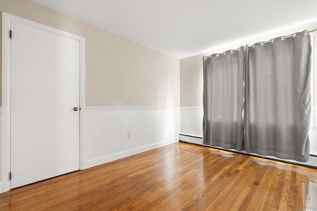 56 Beach St, Woburn, MA 01801 - spare room with wood finished floors and a baseboard heating unit