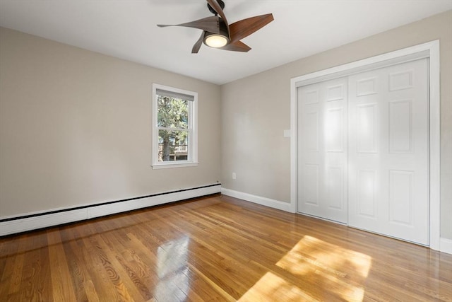 56 Beach St, Woburn, MA 01801 - unfurnished bedroom featuring a baseboard heating unit, wood finished floors, a closet, and a ceiling fan