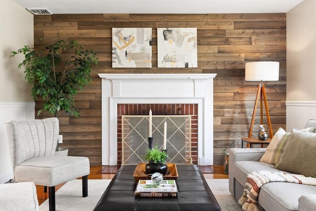 56 Beach St, Woburn, MA 01801 - living area featuring wood walls, a fireplace, light wood-style flooring, and a wainscoted wall