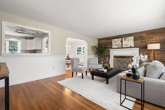 56 Beach St, Woburn, MA 01801 - living room with healthy amount of natural light, arched walkways, wooden walls, and wood finished floors