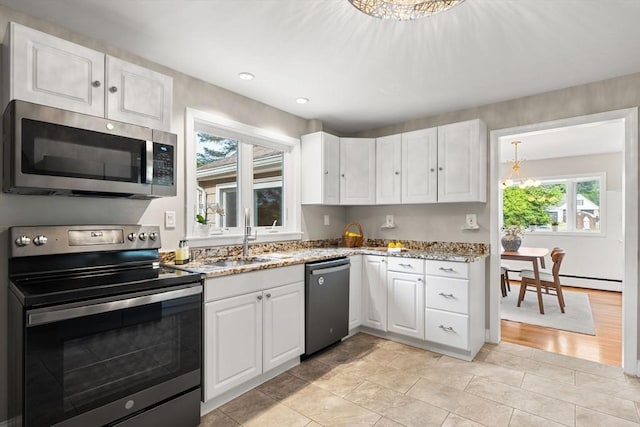 56 Beach St, Woburn, MA 01801 - kitchen featuring stainless steel appliances, white cabinetry, a baseboard radiator, light stone counters, and recessed lighting