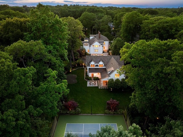 aerial view at dusk featuring a view of trees