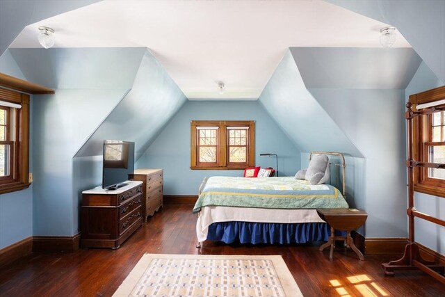 bedroom with hardwood / wood-style floors, baseboards, and lofted ceiling