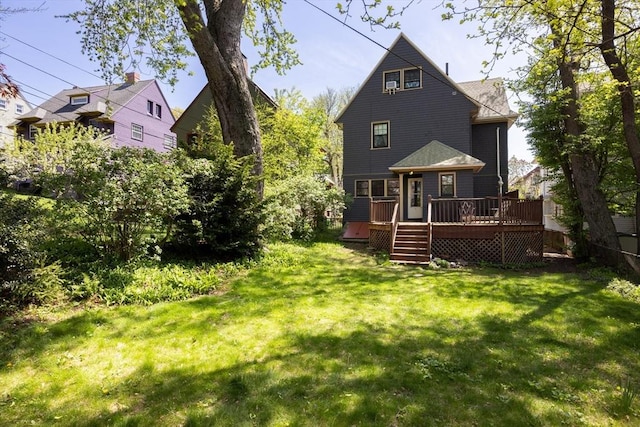 rear view of house featuring a wooden deck and a yard