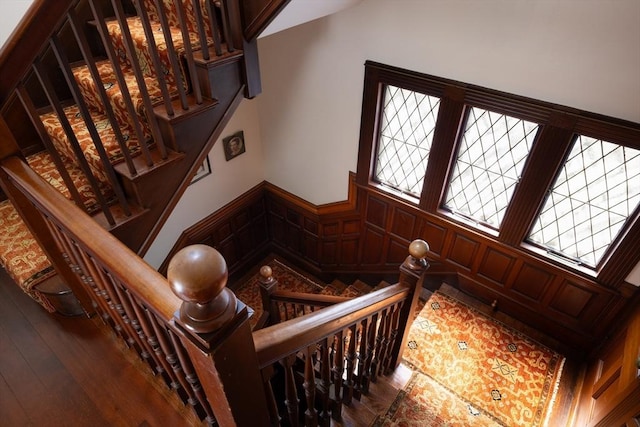 stairway featuring wainscoting and wood-type flooring