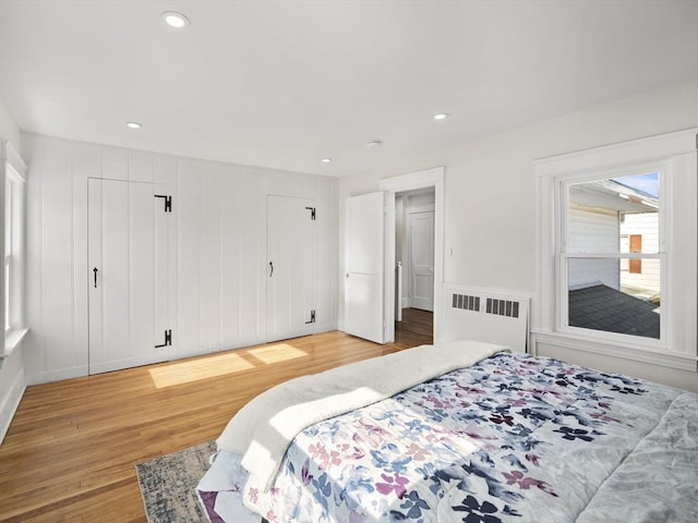 bedroom featuring radiator heating unit and wood-type flooring