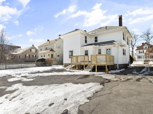 snow covered property with a wooden deck