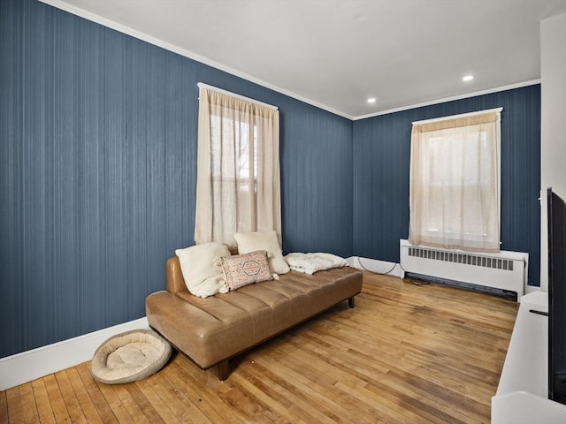 sitting room with radiator, crown molding, and light hardwood / wood-style flooring