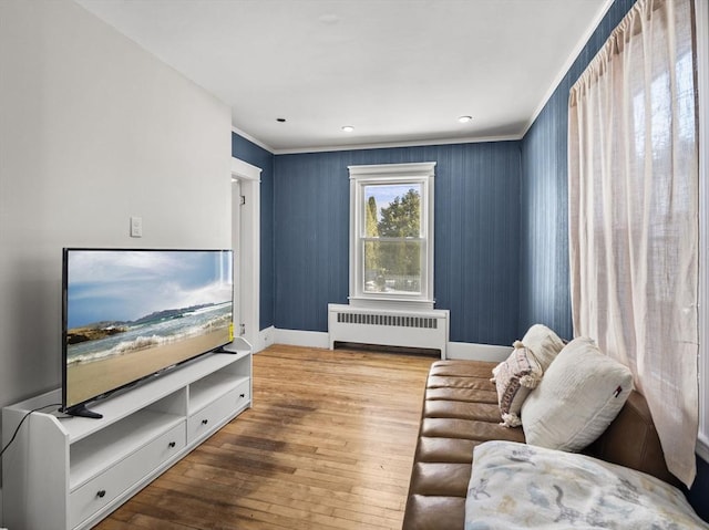 living room featuring crown molding, radiator heating unit, and wood-type flooring