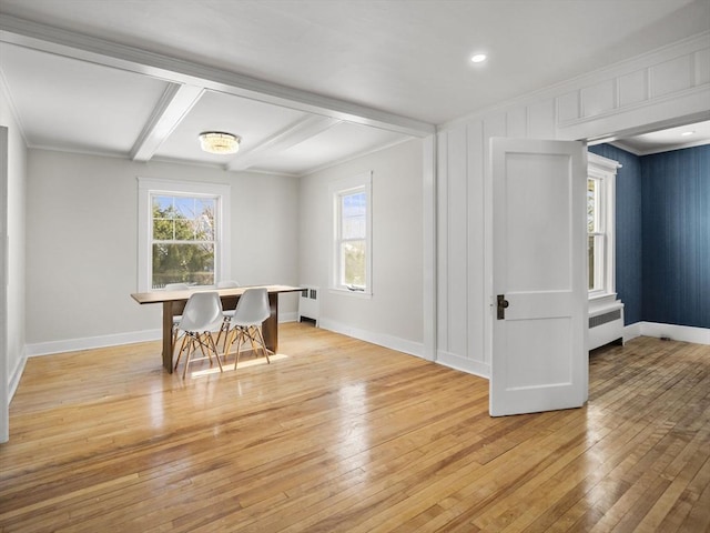 dining space featuring beamed ceiling, crown molding, radiator, and light wood-type flooring