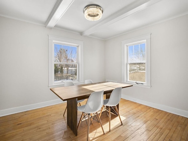 dining area with crown molding, plenty of natural light, light hardwood / wood-style floors, and beamed ceiling