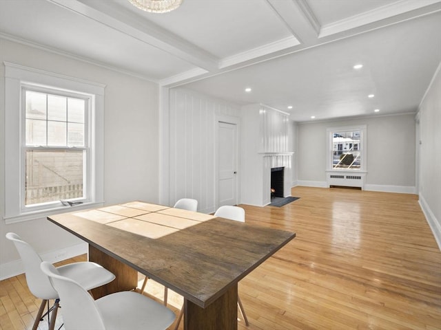 dining room featuring beamed ceiling, a healthy amount of sunlight, radiator heating unit, and light hardwood / wood-style floors