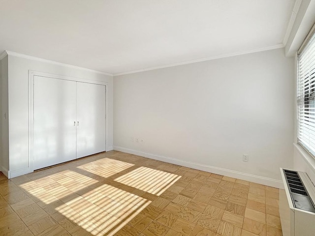 unfurnished bedroom featuring a closet, multiple windows, and ornamental molding