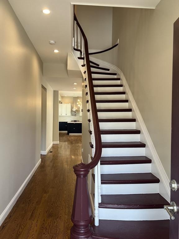 63 Perrin St, Boston, MA 02119 - stairway with wood finished floors, baseboards, and recessed lighting