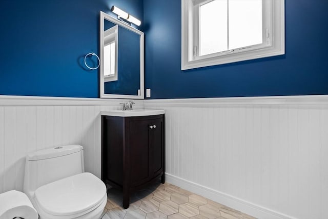 63 Perrin St, Boston, MA 02119 - bathroom featuring a wainscoted wall, vanity, toilet, and baseboards