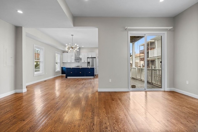 63 Perrin St, Boston, MA 02119 - unfurnished living room featuring a chandelier, wood finished floors, baseboards, and recessed lighting