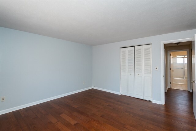 unfurnished bedroom featuring dark hardwood / wood-style floors and a closet