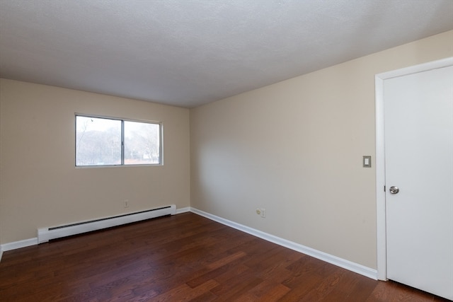 unfurnished room featuring a textured ceiling, dark hardwood / wood-style floors, and a baseboard heating unit