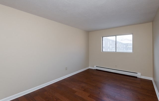 unfurnished room featuring a textured ceiling, dark hardwood / wood-style flooring, and baseboard heating