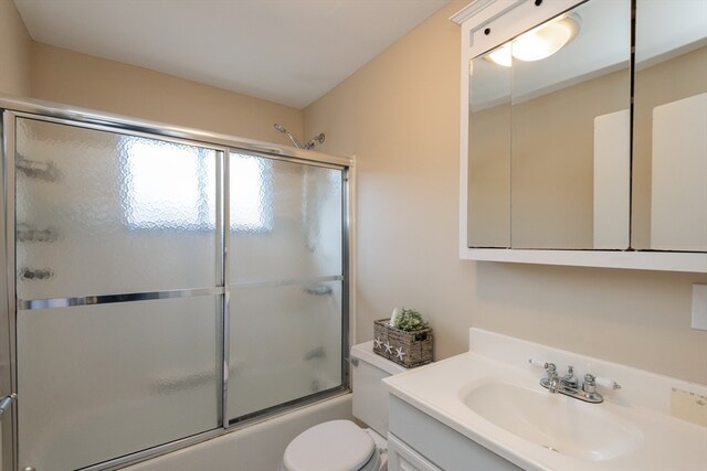 full bathroom with vanity, toilet, and shower / bath combination with glass door