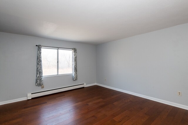 unfurnished room with a baseboard radiator and dark hardwood / wood-style floors