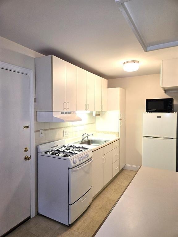 6 Venice St Unit F2, Danvers, MA 01923 - kitchen with white appliances, under cabinet range hood, a sink, white cabinetry, and light countertops
