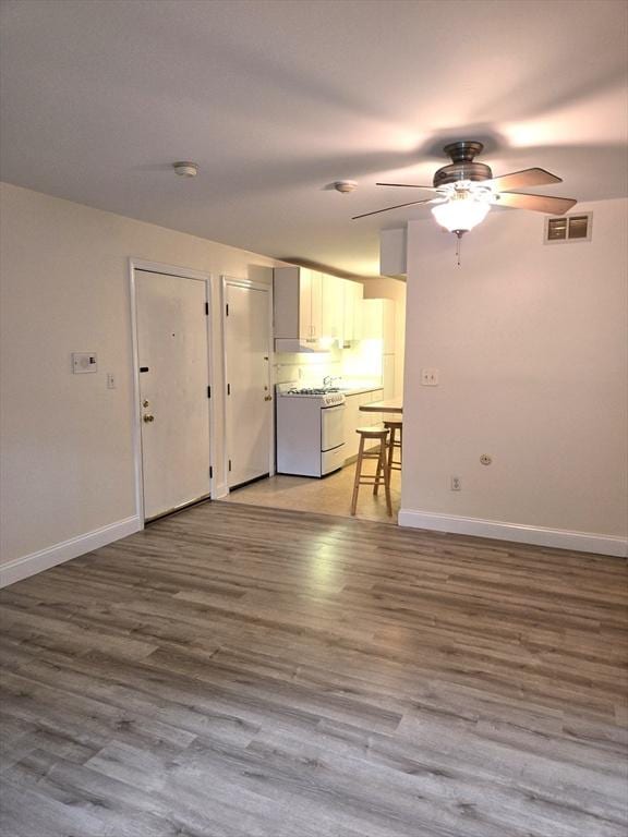 6 Venice St Unit F2, Danvers, MA 01923 - unfurnished living room featuring a ceiling fan, baseboards, and wood finished floors