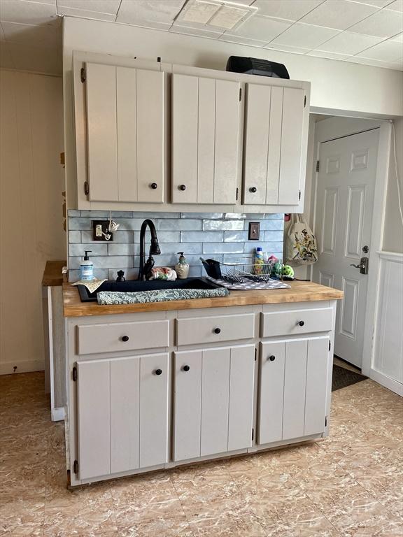 98 Everett St Unit 98, Easthampton, MA 01027 - kitchen with butcher block counters, white cabinetry, and tasteful backsplash