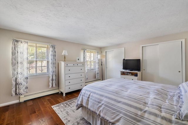 17 York Towne Ter Unit 17, Holden, MA 01520 - bedroom with a baseboard heating unit, multiple windows, two closets, dark wood-type flooring, and a textured ceiling