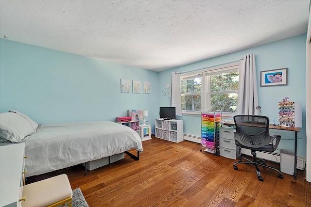 17 York Towne Ter Unit 17, Holden, MA 01520 - bedroom with a baseboard radiator, wood finished floors, a desk, and a textured ceiling