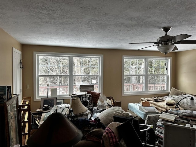 bedroom featuring multiple windows, a ceiling fan, and a textured ceiling