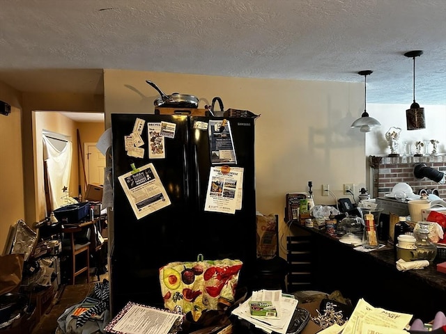 interior space featuring freestanding refrigerator and a textured ceiling