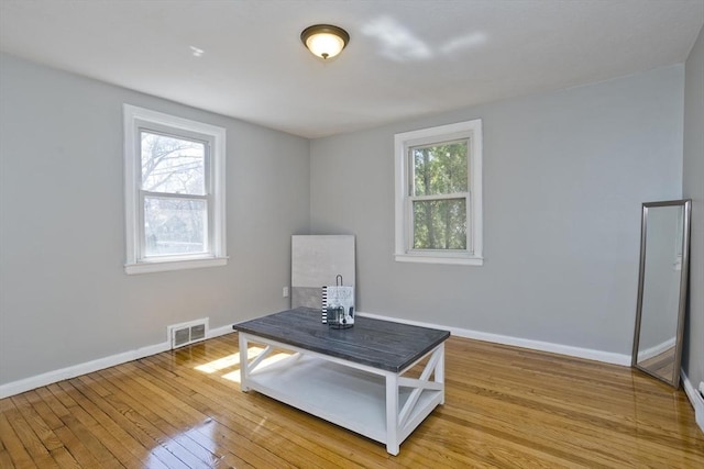 living area featuring baseboards, visible vents, and light wood-style floors