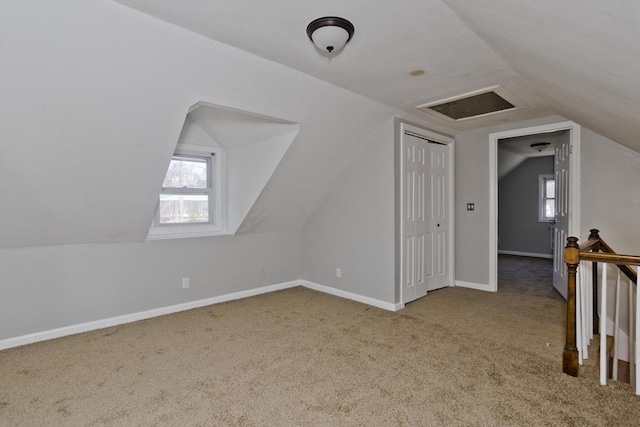 additional living space with carpet floors, baseboards, a wealth of natural light, and lofted ceiling