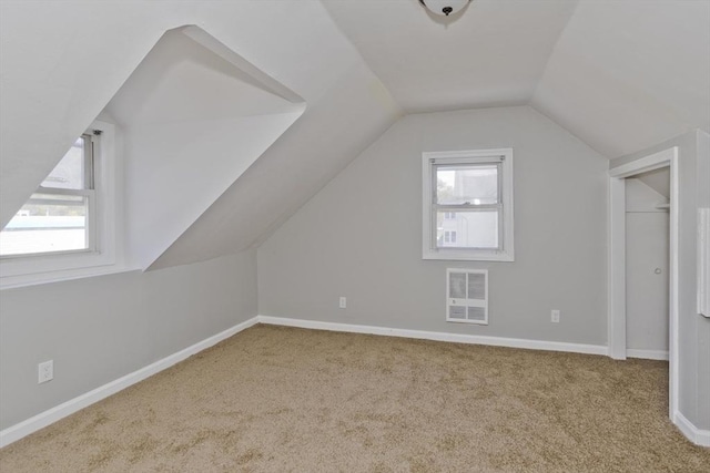 bonus room with heating unit, carpet floors, baseboards, and lofted ceiling