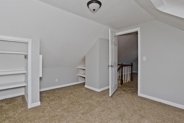 additional living space featuring carpet flooring, baseboards, and vaulted ceiling