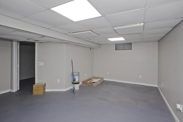 finished below grade area with baseboards and a drop ceiling