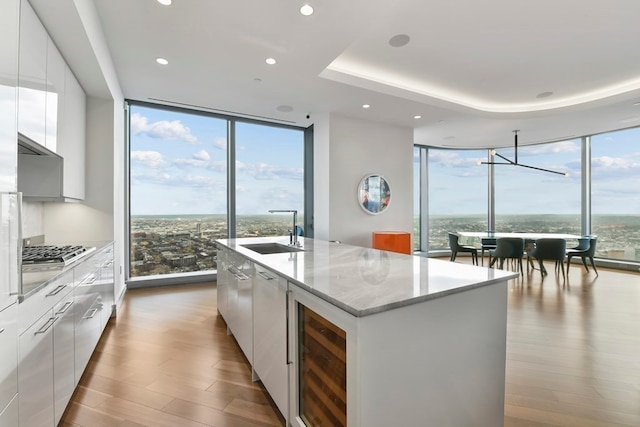 kitchen featuring light hardwood / wood-style floors, a wealth of natural light, sink, and white cabinetry