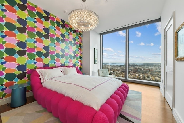 bedroom with a wall of windows, a notable chandelier, and light hardwood / wood-style floors