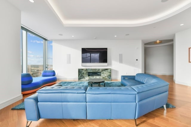 living room with light hardwood / wood-style flooring, floor to ceiling windows, and a fireplace