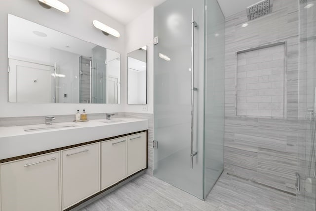 bathroom with an enclosed shower and dual bowl vanity