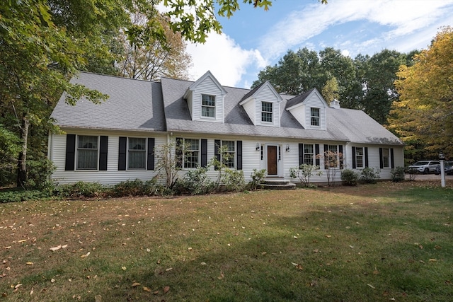 cape cod home featuring a front yard