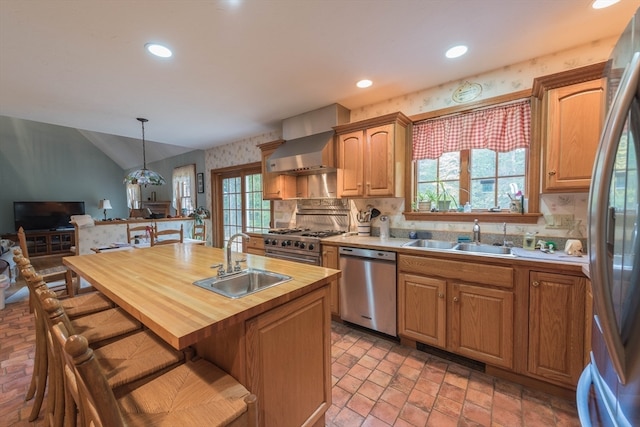 kitchen featuring a healthy amount of sunlight, sink, stainless steel appliances, and decorative light fixtures