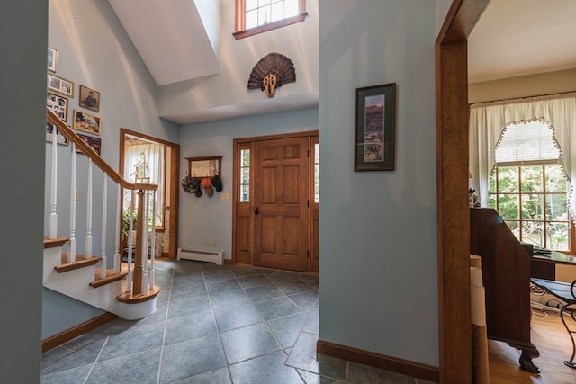 foyer entrance with a high ceiling and baseboard heating