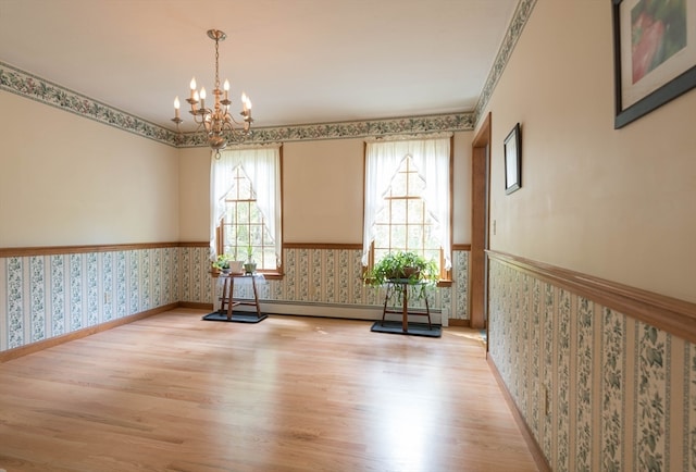 interior space featuring light hardwood / wood-style floors, a baseboard heating unit, and a wealth of natural light