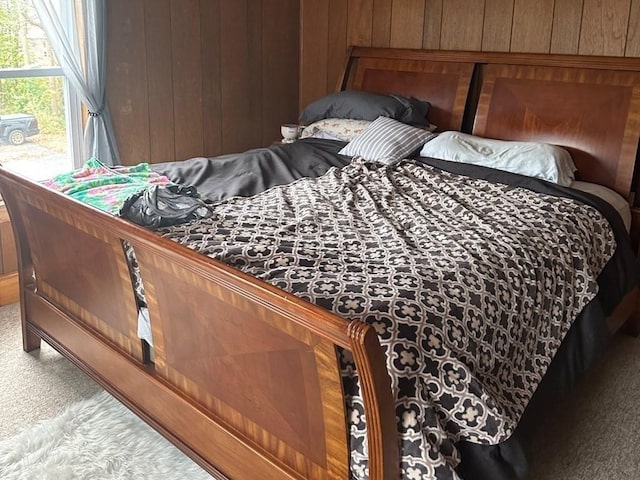 carpeted bedroom with wooden walls