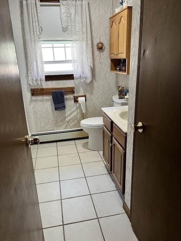 bathroom featuring tile patterned floors, baseboard heating, vanity, and toilet