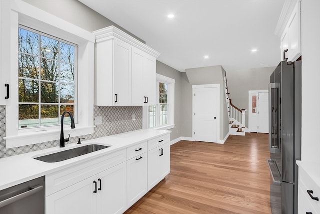 kitchen featuring sink, a healthy amount of sunlight, light wood-type flooring, and appliances with stainless steel finishes