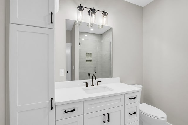 bathroom featuring vanity, toilet, and a shower with shower door